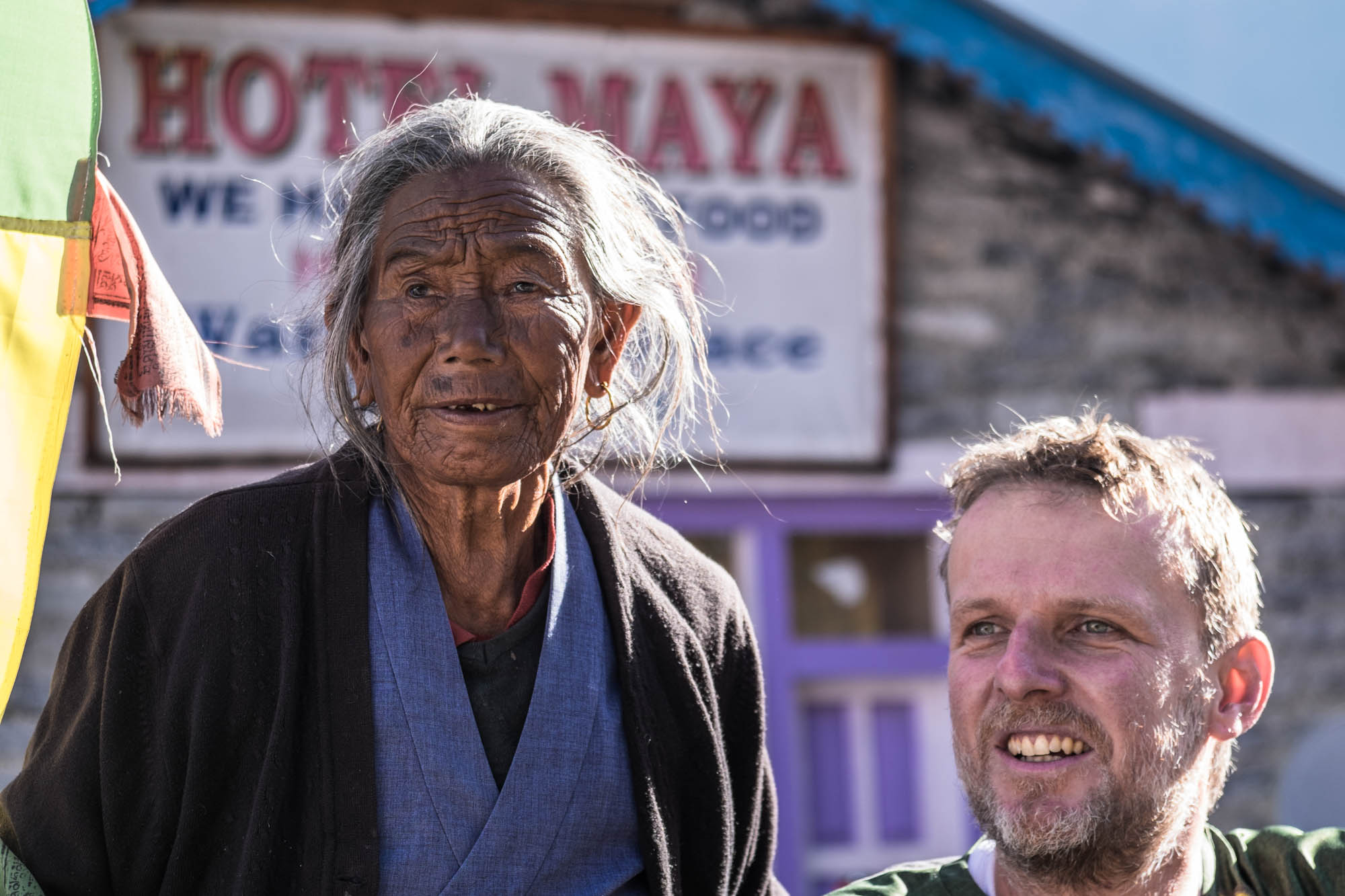 Eine alte Nepalesin mit zerfurchtem Gesicht steht neben Jens Vögele