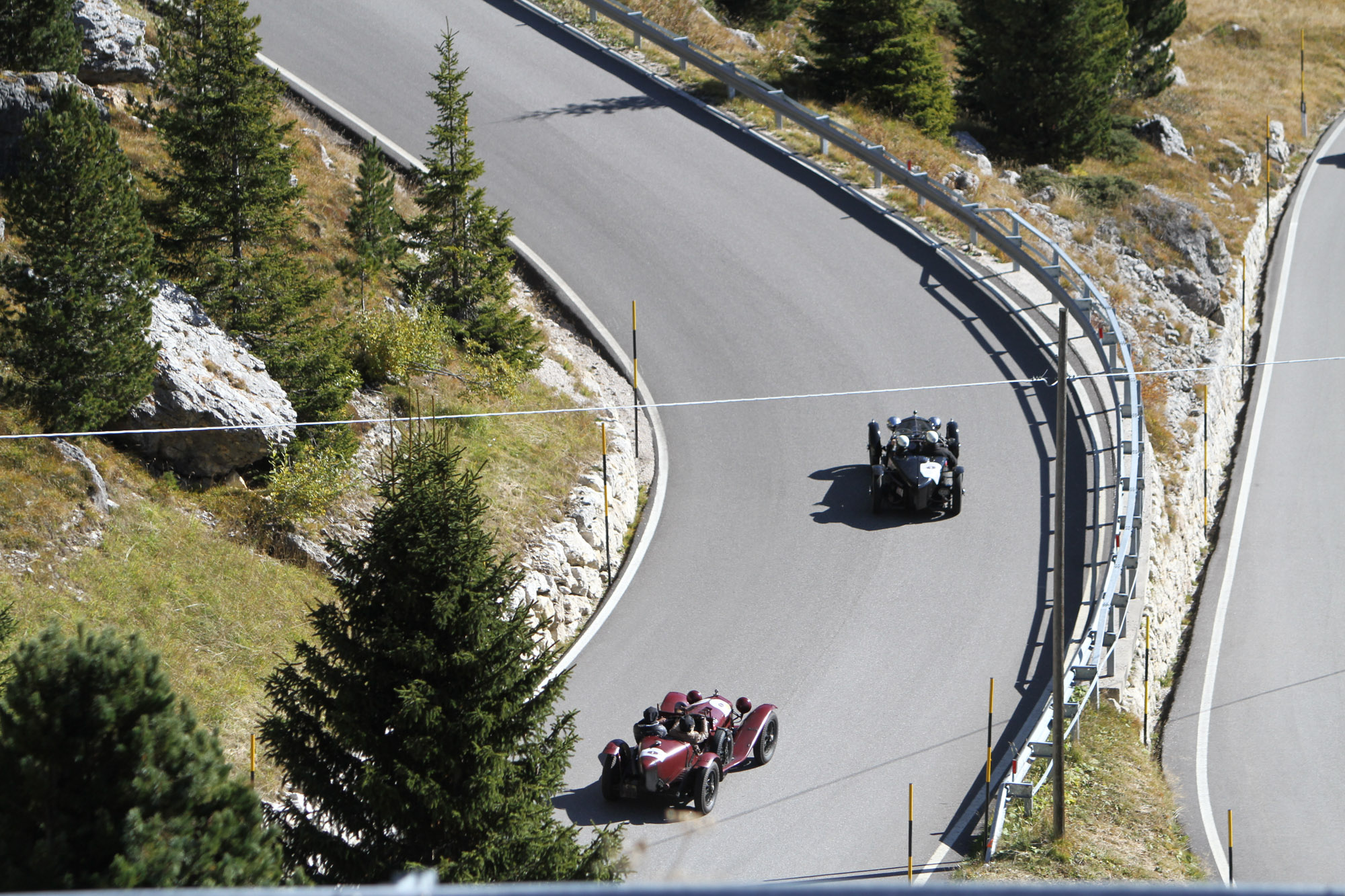 Zwei Oldtimer fahren eine Passstraße hoch