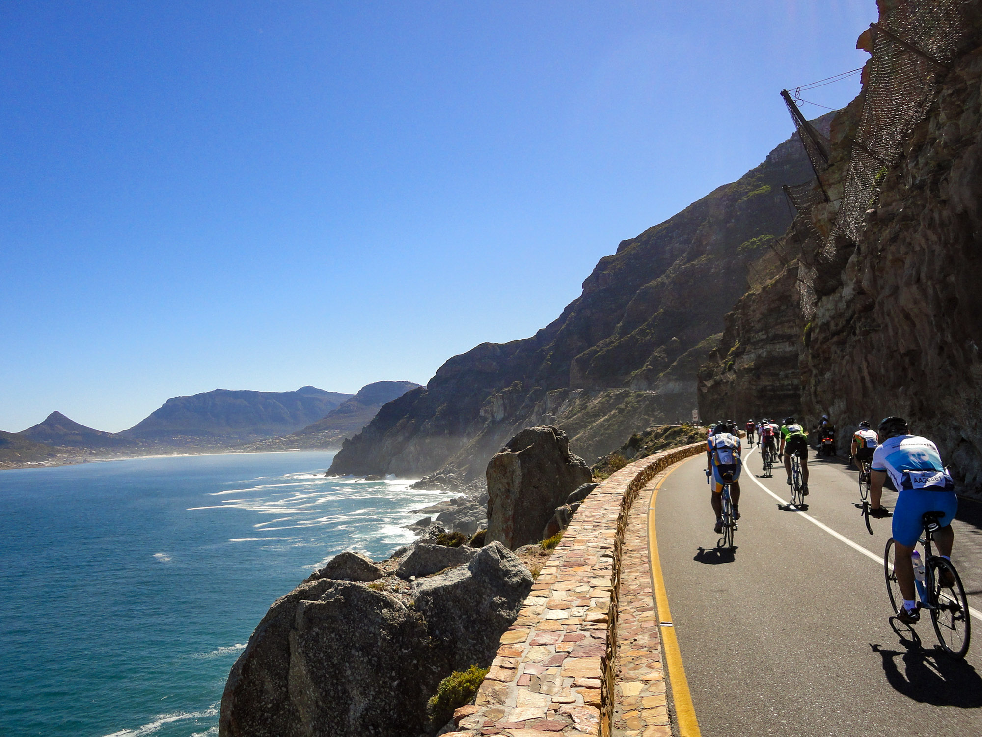 Beim Cape Argus: Rennradfahrer fahren auf einer Küstenstraße