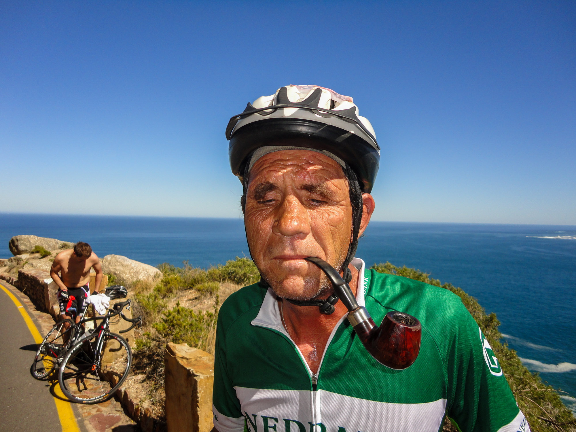 Beim Cape Argus: Ein Fahrradfahrer macht eine Pause und raucht dabei eine Pfeife