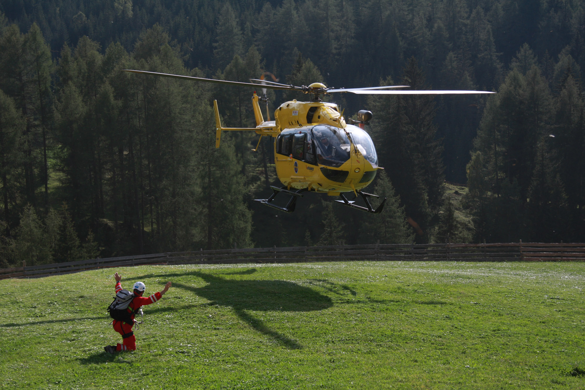 Ein Hubschrauber der Bergrettung landet auf einer Wiese