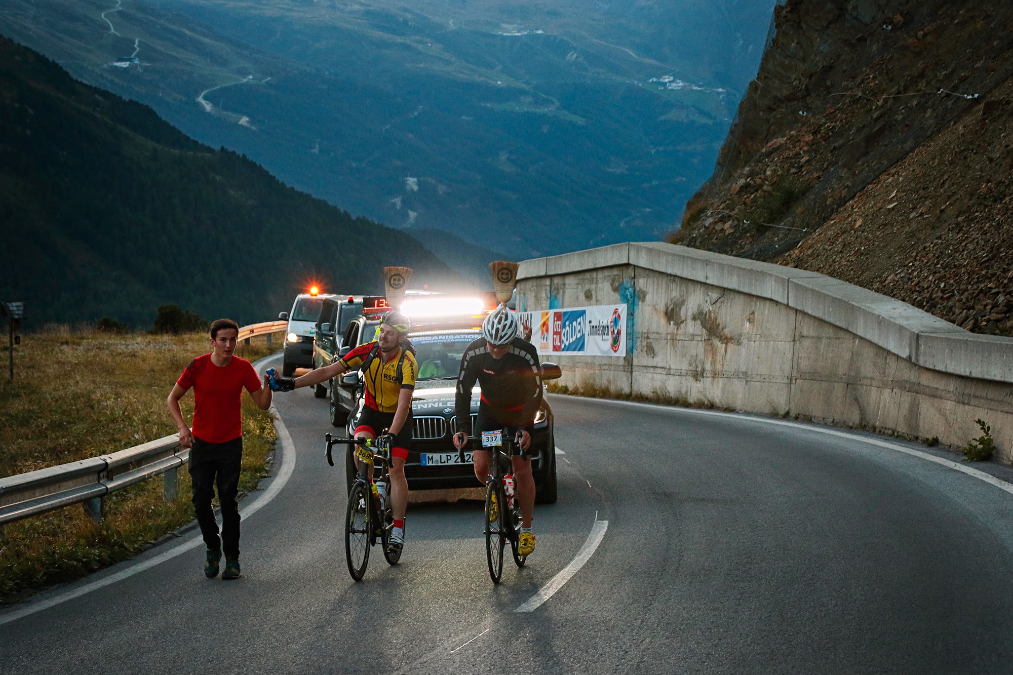 Zwei Radfahrer kämpfen sich den Berg hoch, dicht gefolgt vom Besenwagen. Sie werden Letzter beim Ötztaler Radmarathon