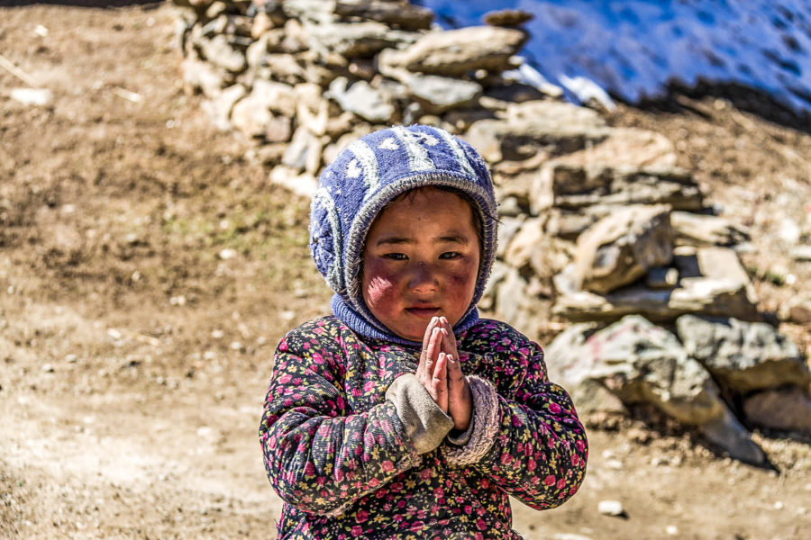 Ein Kind faltet die Hände zum typisch nepalesischen Gruß