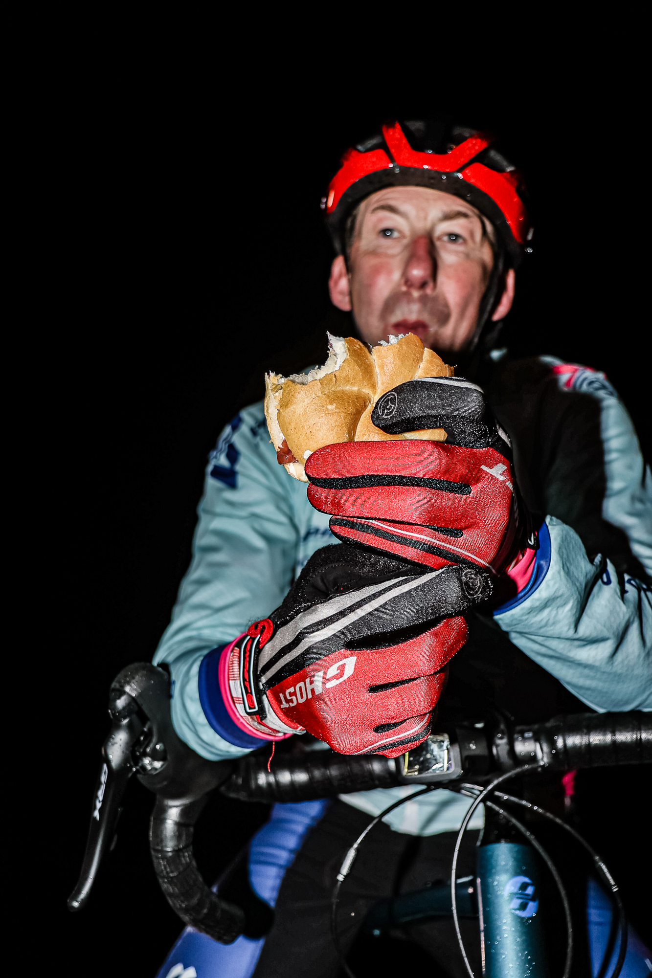 Extremsportler Guido Kunze isst mitten in der Nacht ein Brötchen.